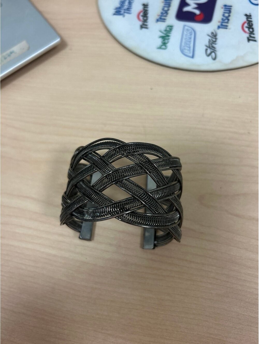 Dark silver-tone cuff bracelet featuring an intricate interwoven wire lattice